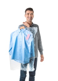 Photo of Young man holding hanger with shirt in plastic bag on white background. Dry-cleaning service