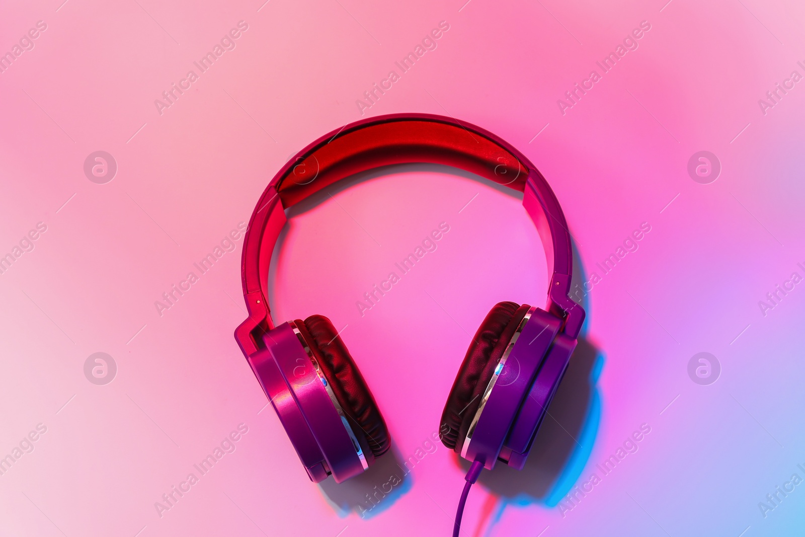 Photo of Stylish headphones on color background, top view