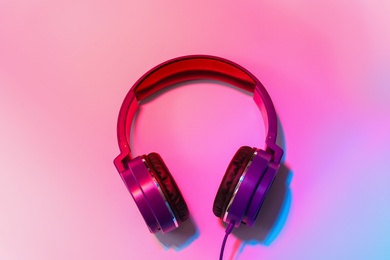 Photo of Stylish headphones on color background, top view