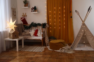 Photo of Cozy children's room with bed, toys and Christmas decor. Interior design