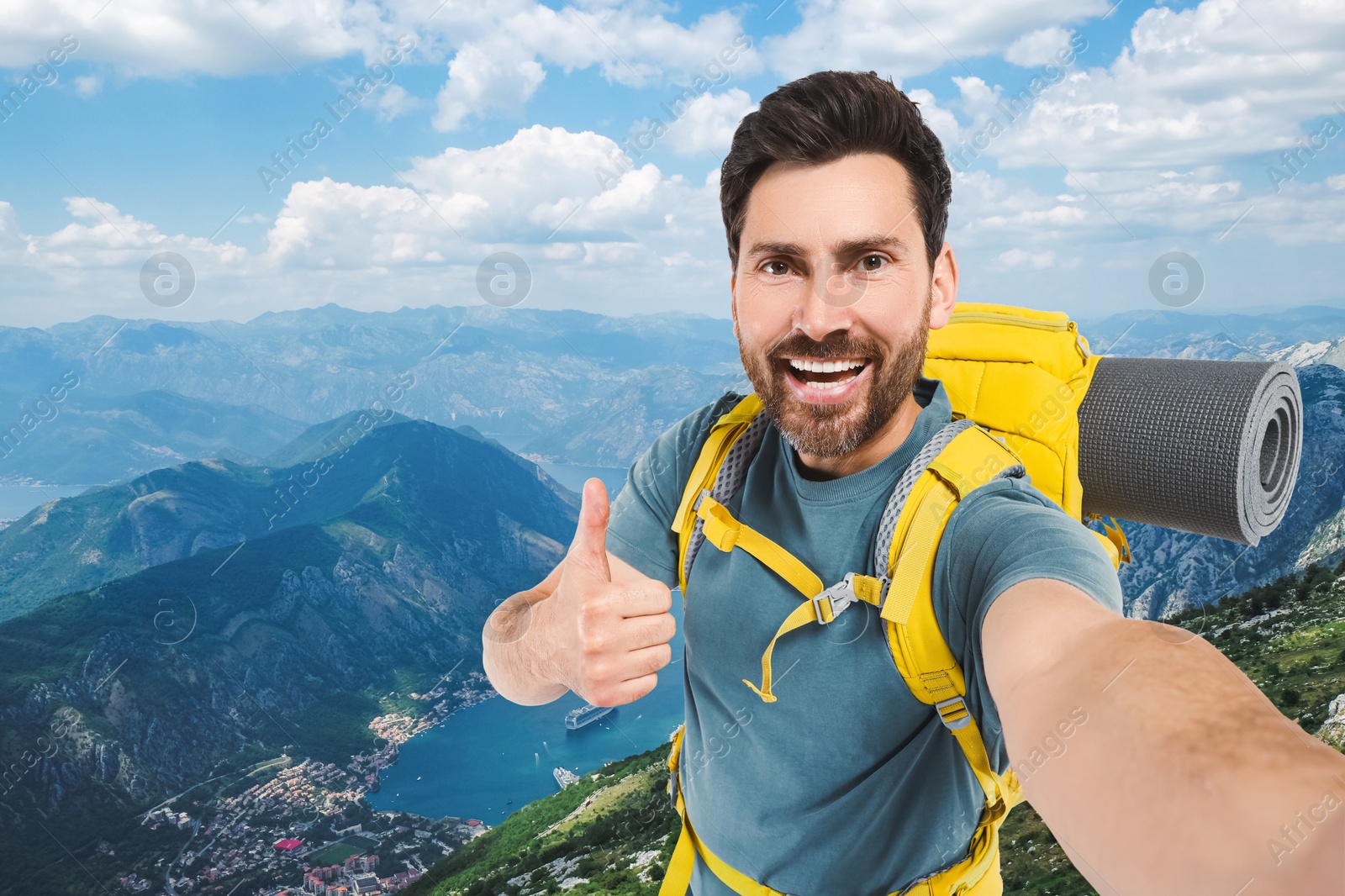 Image of Happy tourist with backpack taking selfie in mountains