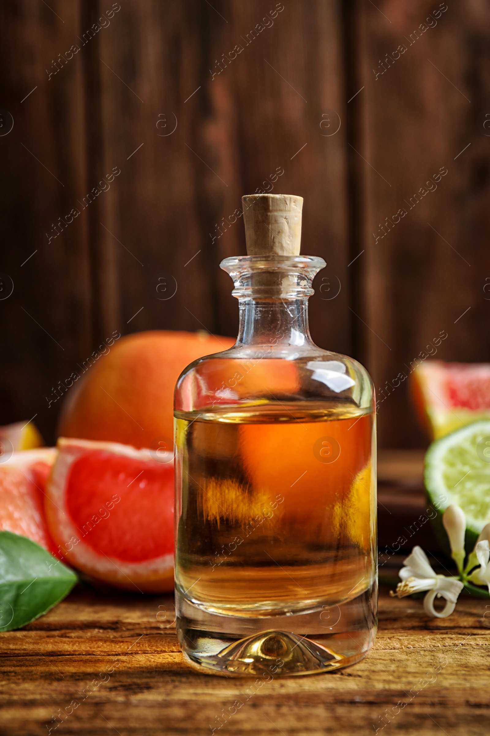 Photo of Bottle of citrus essential oil on wooden table