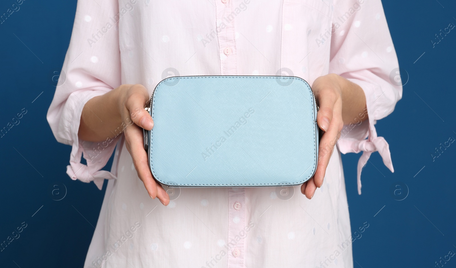 Photo of Young woman with stylish bag on blue background, closeup