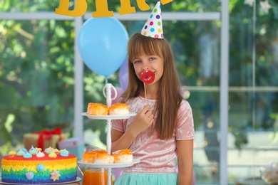 Photo of Happy girl in room decorated for birthday party