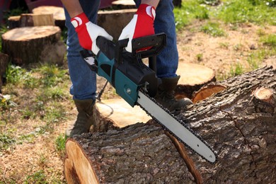 Man sawing wooden log on sunny day, closeup