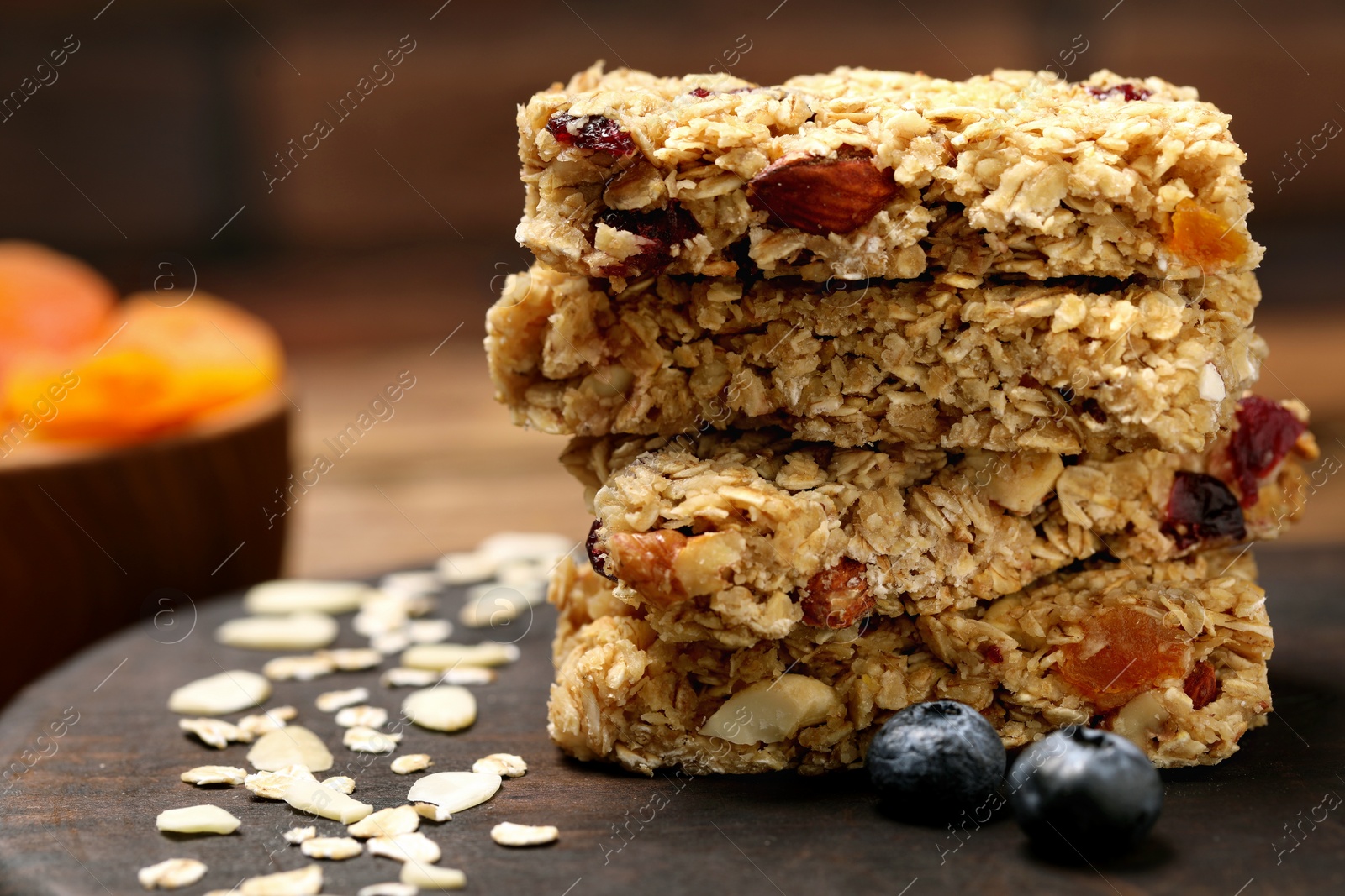 Photo of Stack of tasty granola bars on table, closeup. Space for text
