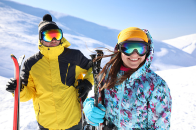 Photo of Young couple with skis on hill. Winter vacation