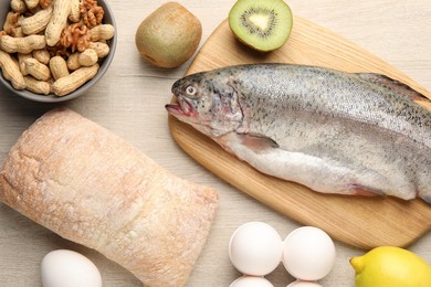 Photo of Allergenic food. Different fresh products on wooden table, flat lay