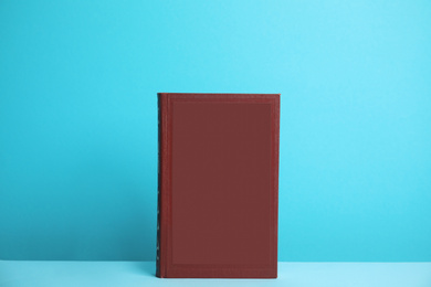 Hardcover book on blue background. Space for design