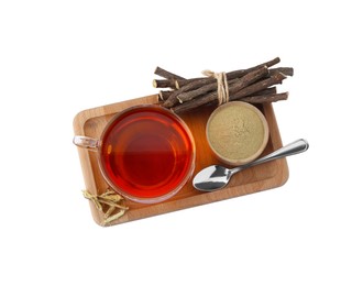 Photo of Aromatic licorice tea in cup, dried sticks of licorice root, powder and spoon on white background, top view