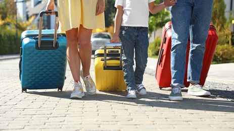 Photo of Family with suitcases walking outdoors. Moving day