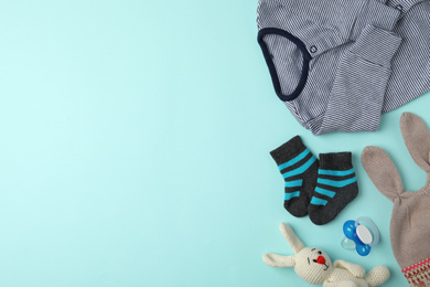 Photo of Flat lay composition with child's clothes and accessories on light blue background, space for text