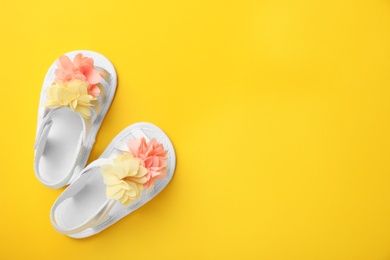 Photo of Pair of cute baby sandals on color background, top view