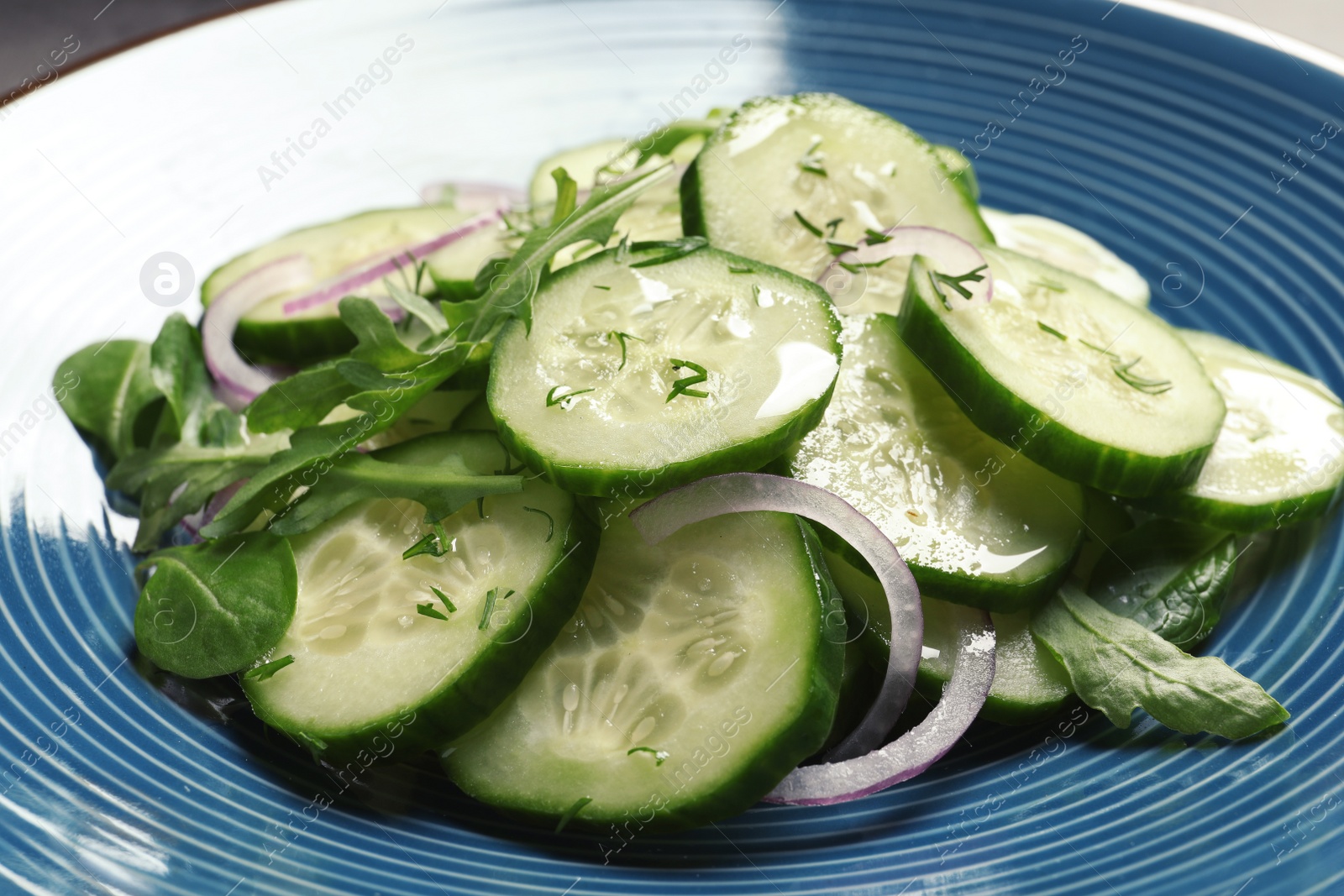 Photo of Tasty fresh cucumber salad on plate, closeup