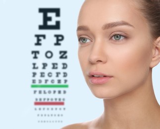 Young woman and blurred eye chart on background. Visiting ophthalmologist 