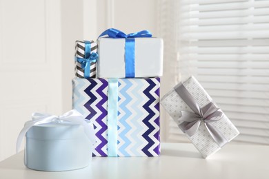 Heap of wrapped gift boxes on white table. Happy holiday