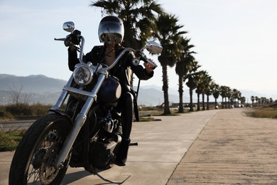 Photo of Woman in helmet sitting on motorcycle outdoors