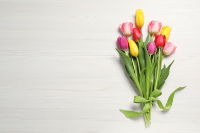 Photo of Beautiful tulips on white wooden table, flat lay. Space for text