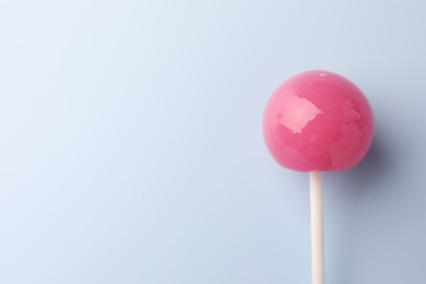 Photo of Tasty lollipop on light blue background, top view. Space for text