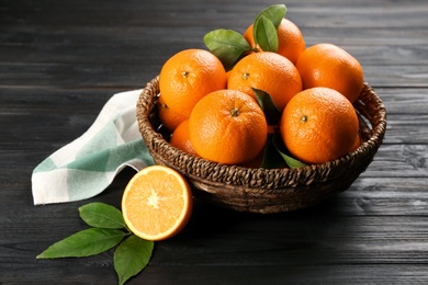 Photo of Delicious ripe oranges on black wooden table