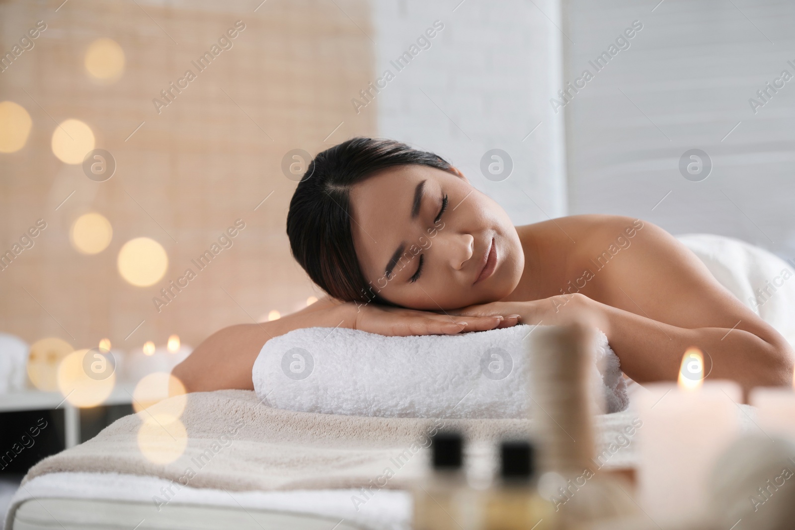 Photo of Beautiful Asian woman lying on massage table in spa salon