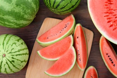 Photo of Different cut and whole ripe watermelons on wooden table, flat lay