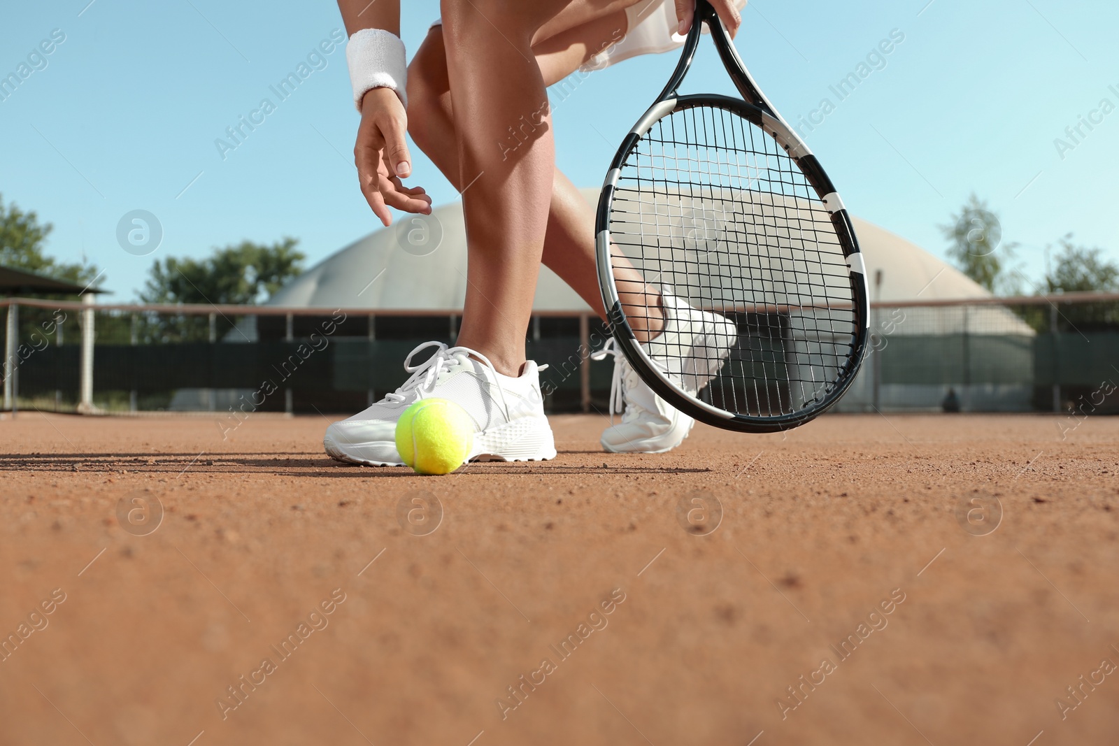 Photo of Sportswoman playing tennis at court on sunny day, closeup