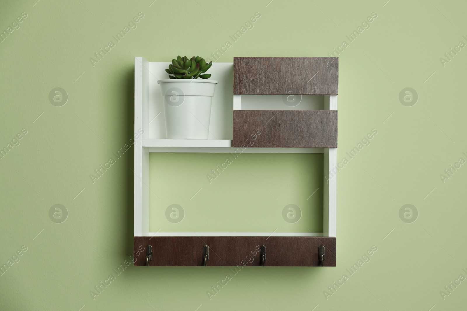 Photo of Wooden hanger for keys on light green wall