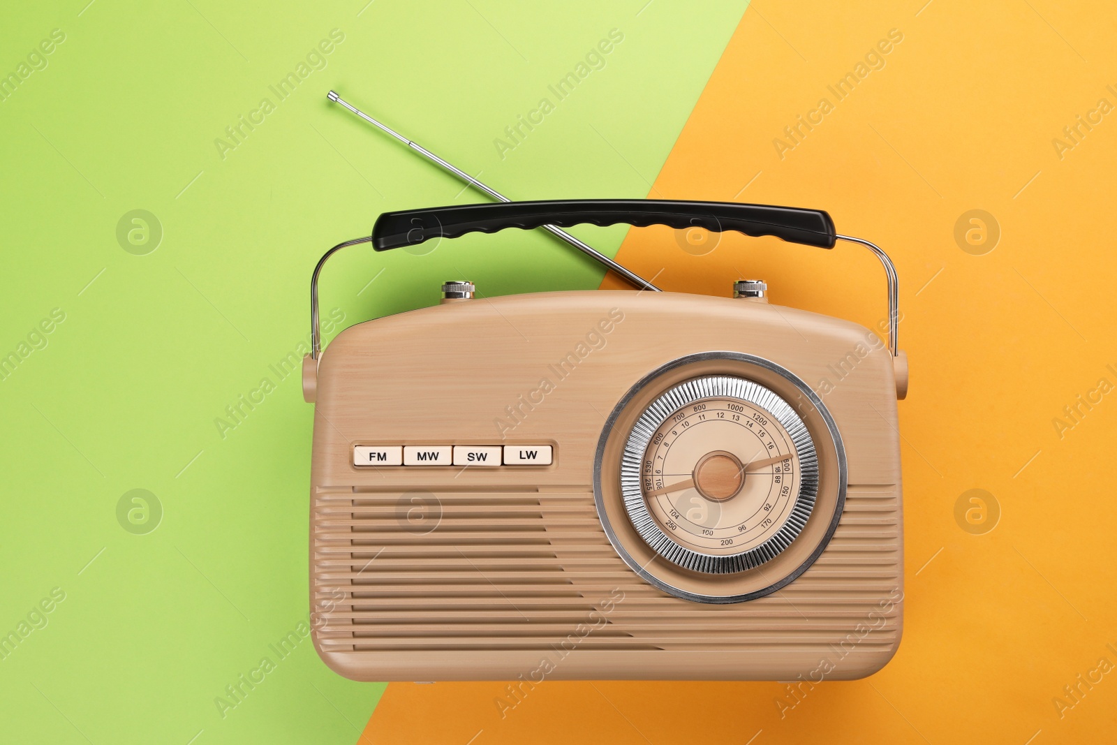 Photo of Retro radio receiver on color background, top view