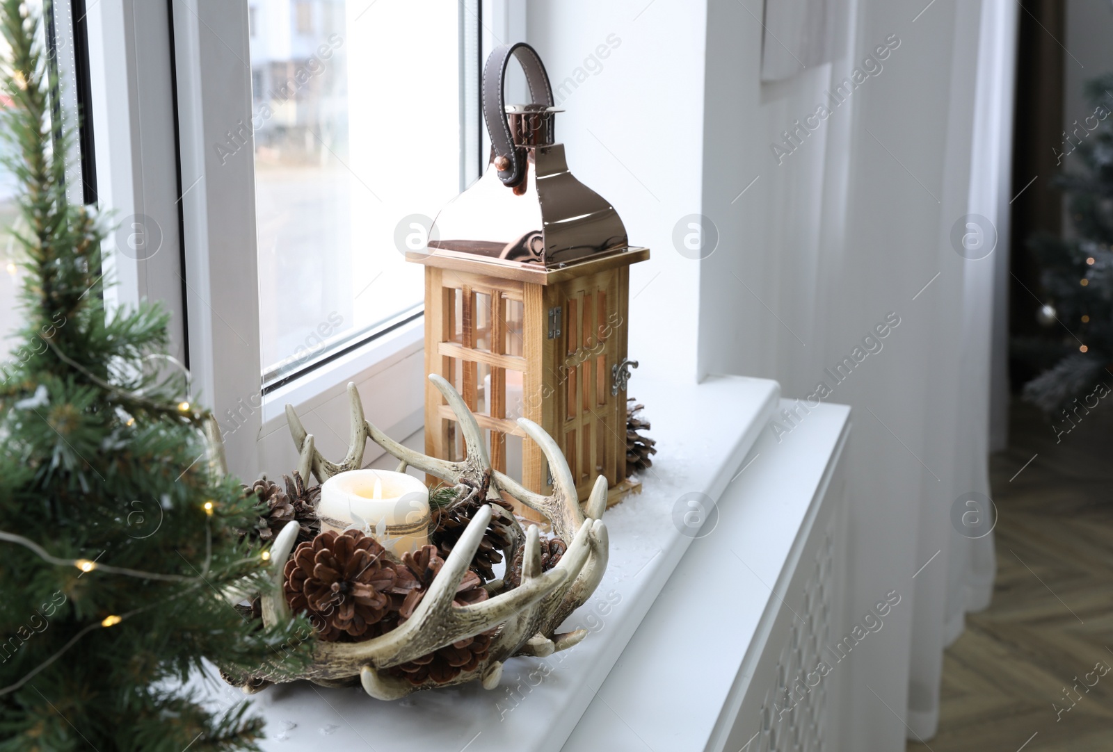 Photo of Beautiful Christmas lantern and other decorations on window sill