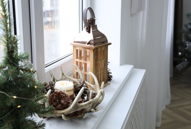 Beautiful Christmas lantern and other decorations on window sill