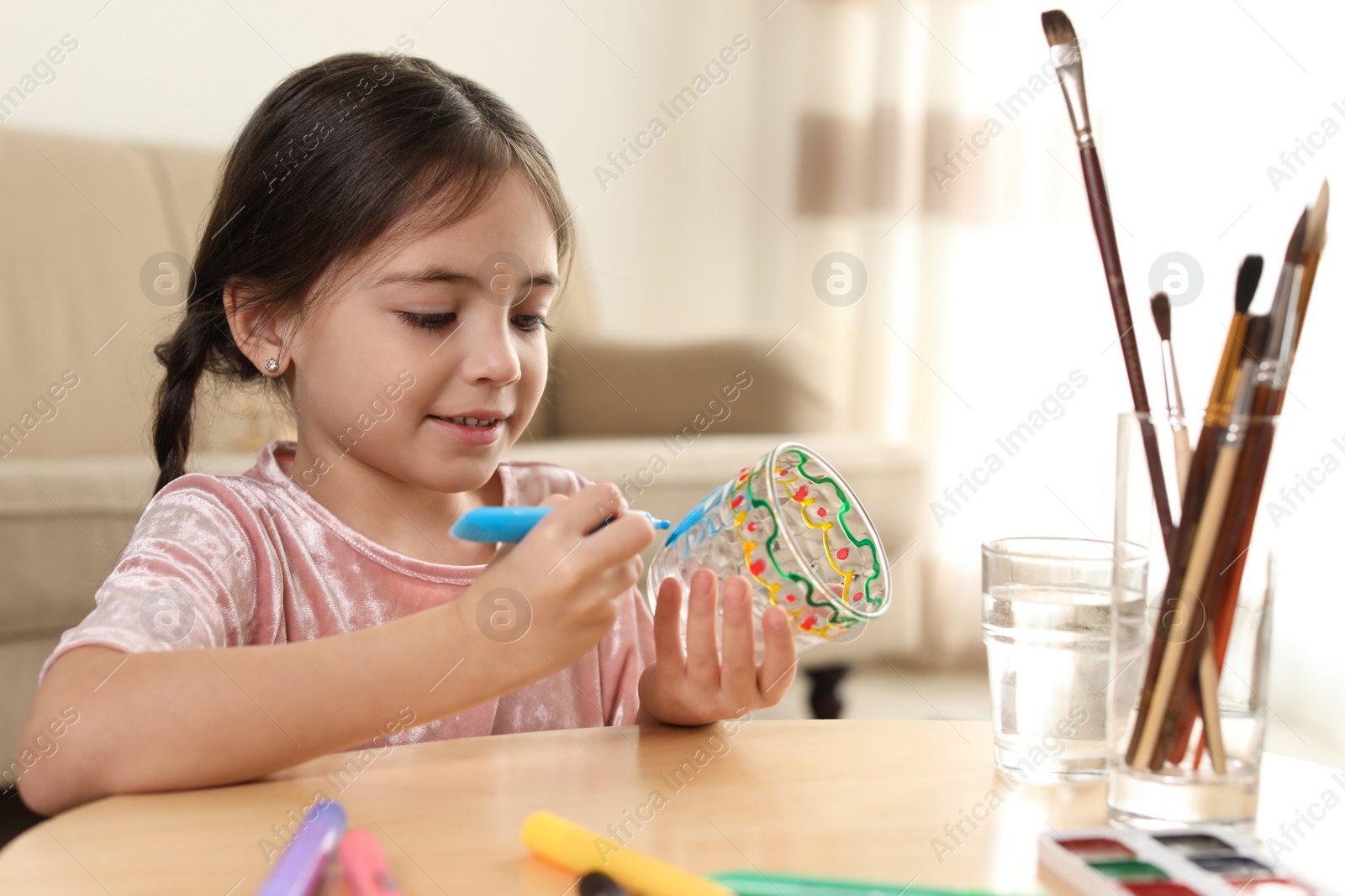 Photo of Little girl painting glass at table indoors. Creative hobby