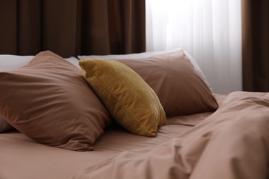 Bed with brown linens in stylish room