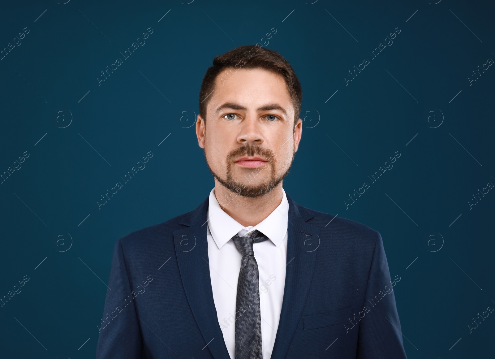 Photo of Portrait of handsome man in suit on blue background