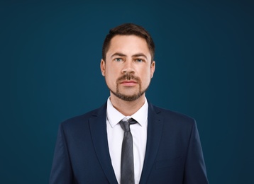 Portrait of handsome man in suit on blue background