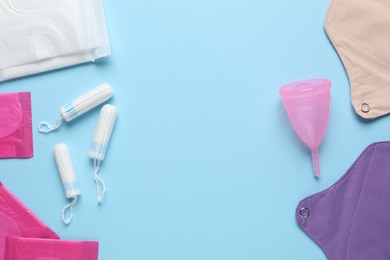 Photo of Different menstrual hygiene products on light blue background, flat lay. Space for text
