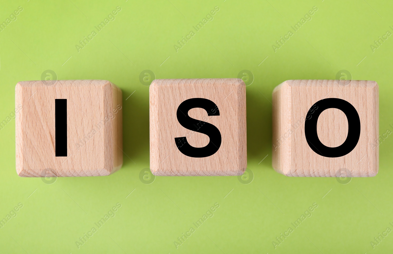 Photo of International Organization for Standardization. Wooden cubes with abbreviation ISO on light green background, top view