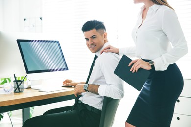 Image of Young woman flirting with her colleague during work in office. Cheating concept