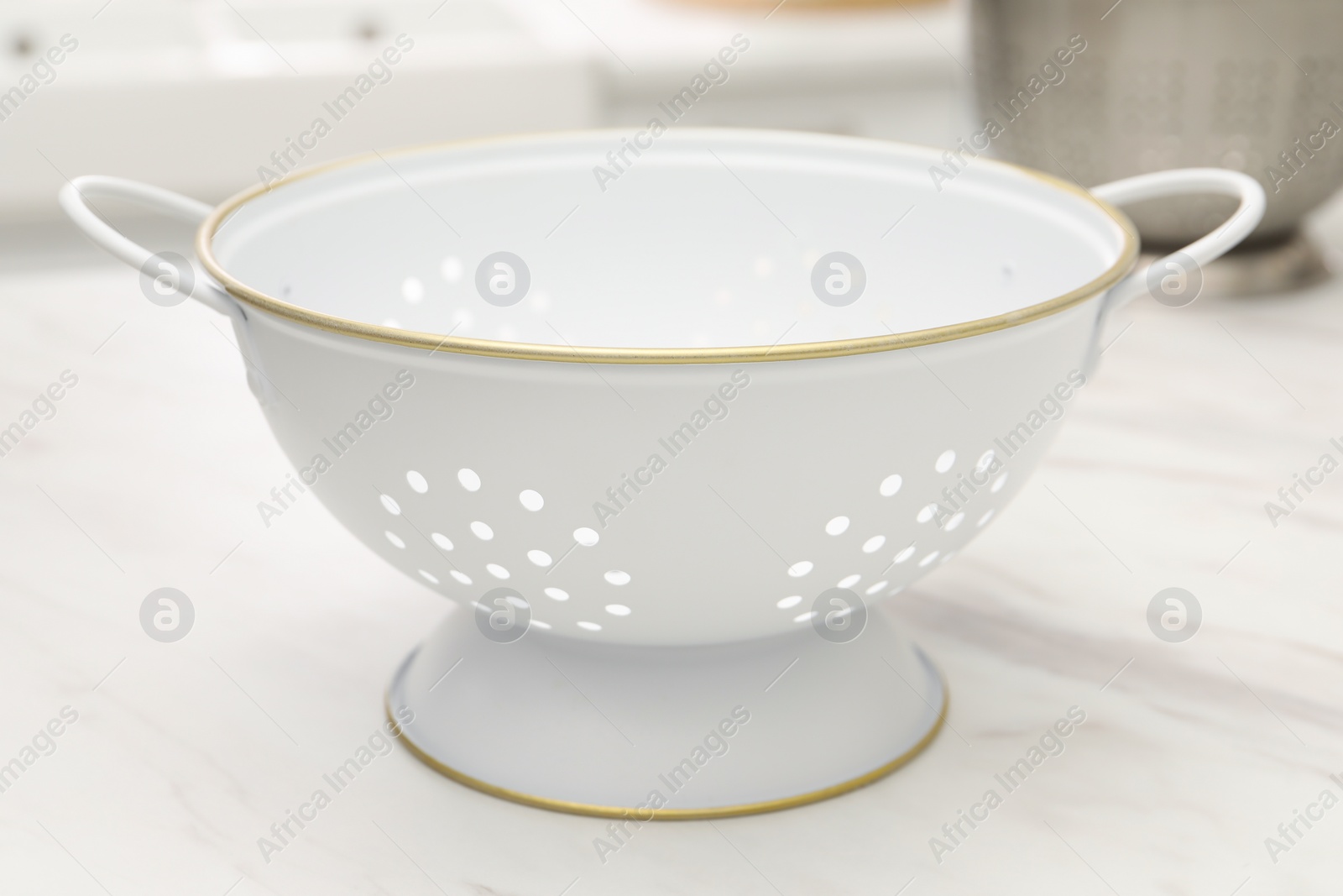 Photo of Clean empty colander on white marble table, closeup