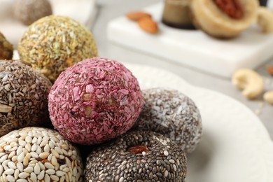 Photo of Different delicious vegan candy balls on plate, closeup. Space for text