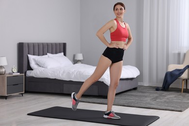 Photo of Happy woman doing morning exercise at home, space for text