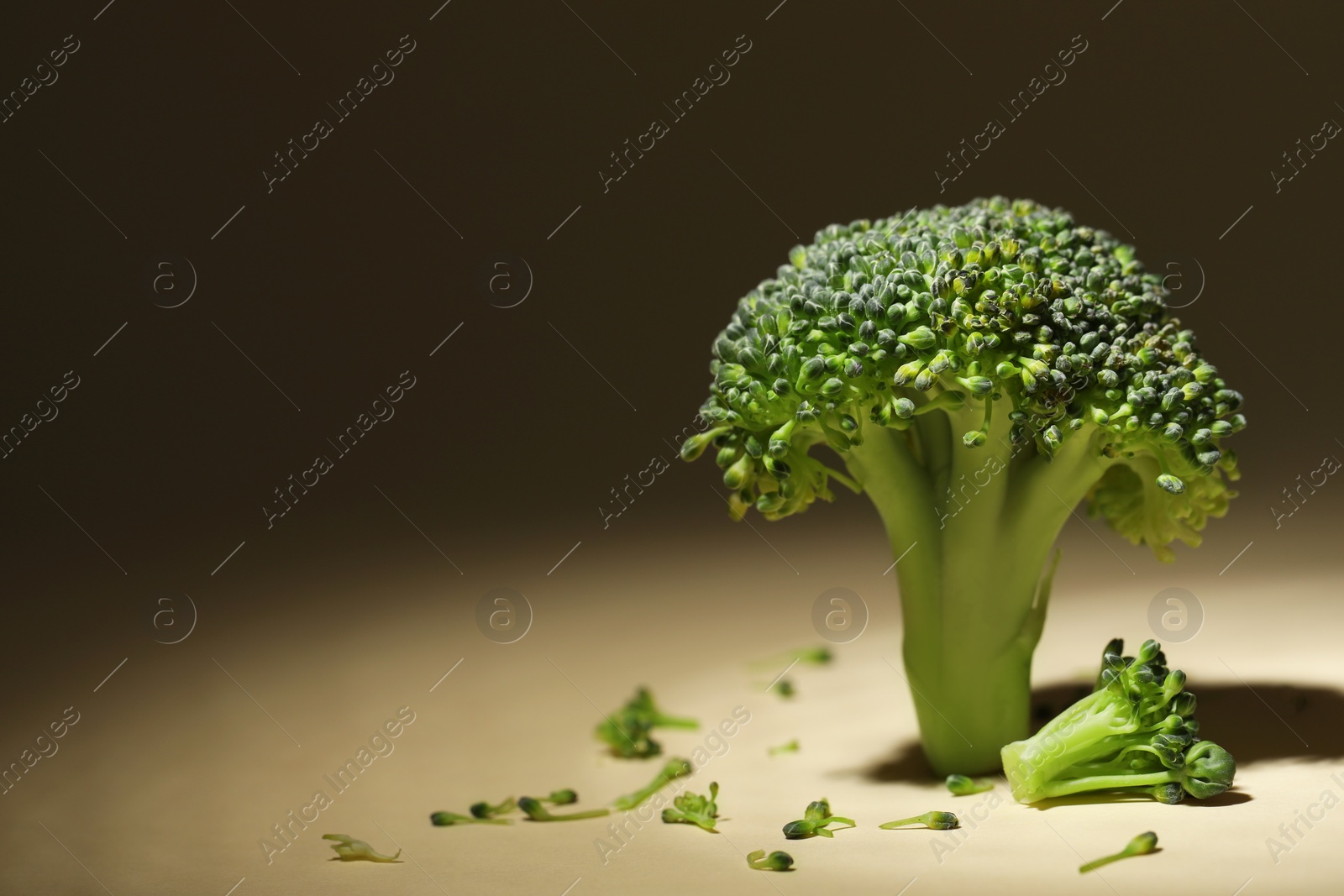 Photo of Fresh raw broccoli on beige background, closeup. Space for text