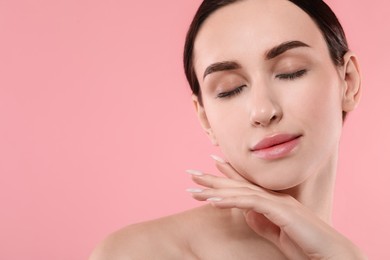 Portrait of beautiful young woman on pink background. Space for text