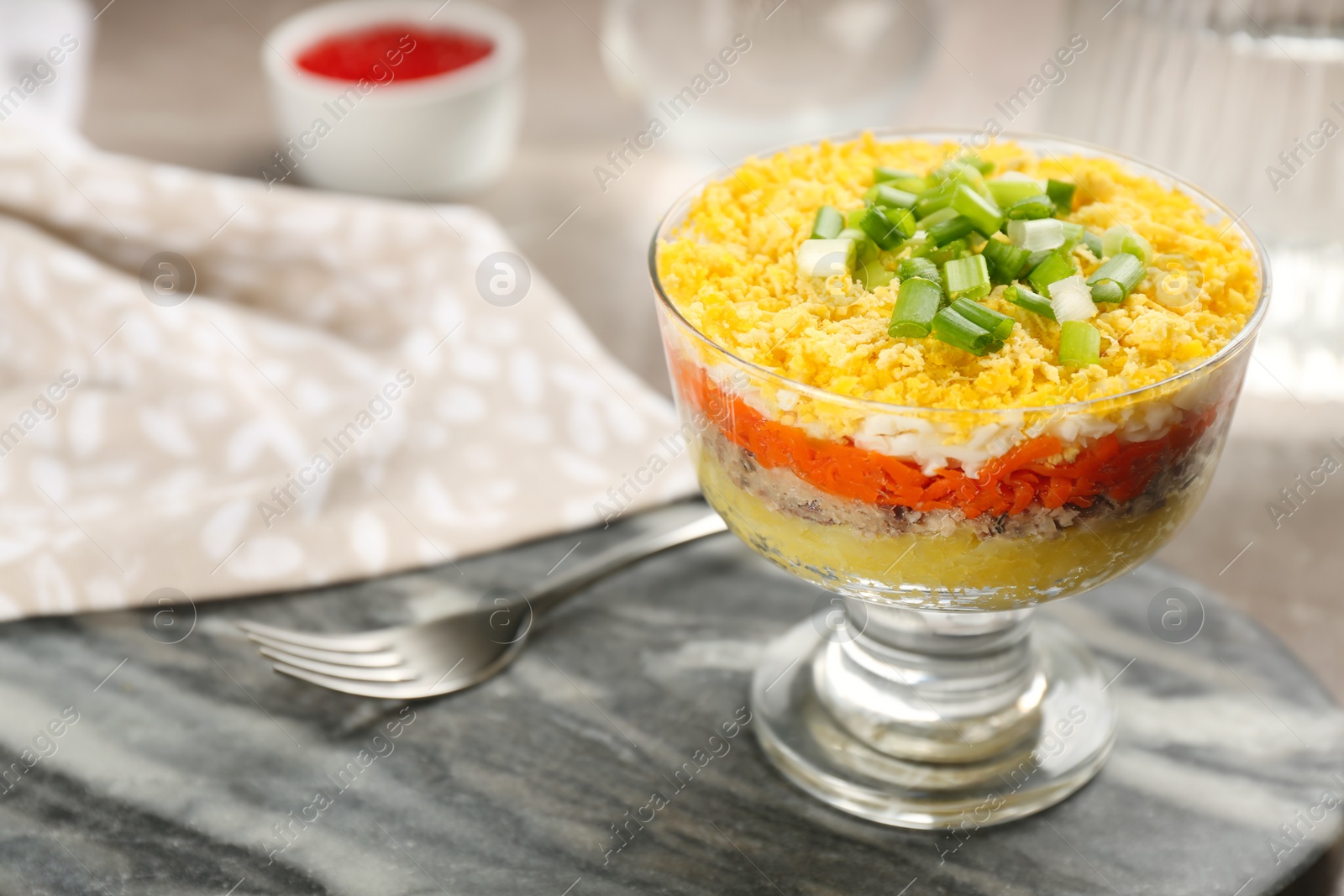 Photo of Traditional russian salad Mimosa in bowl on grey board, closeup. Space for text