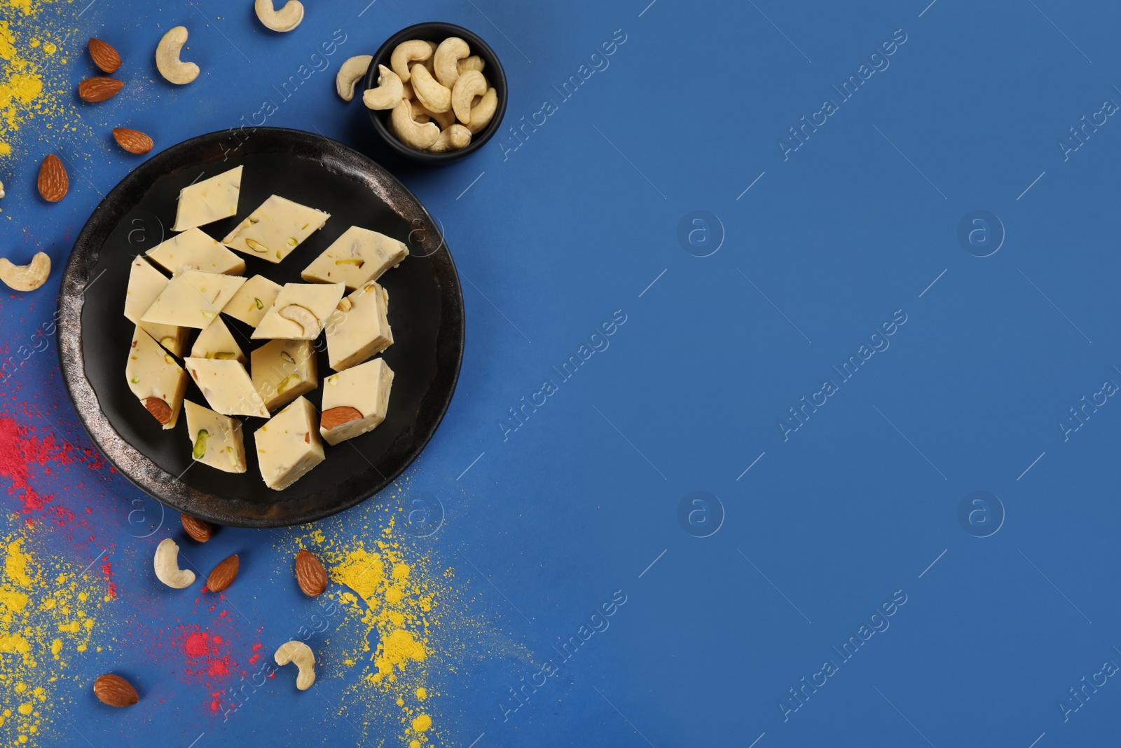 Photo of Traditional Indian food and color powders on blue background, flat lay with space for text. Holi festival celebration