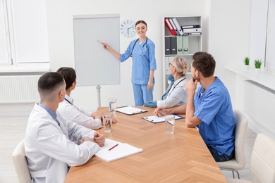 Photo of Doctor giving lecture near flipchart in conference room