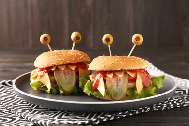 Photo of Cute monster burgers on table. Halloween party food