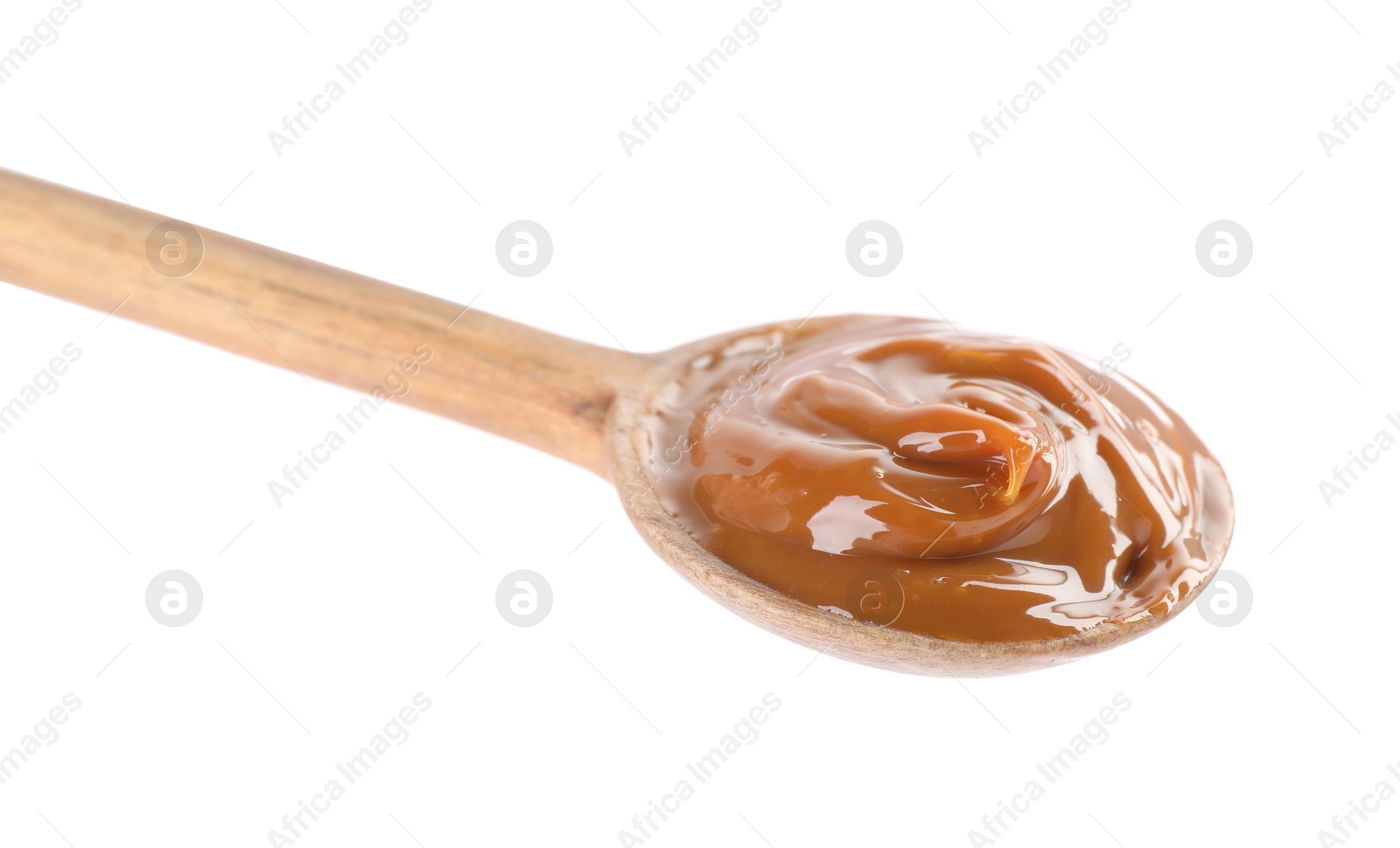 Photo of Wooden spoon with tasty boiled condensed milk isolated on white