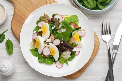 Photo of Delicious salad with boiled egg, radish and cheese served on white wooden table, flat lay
