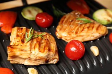 Photo of Tasty meat, spices and vegetables on electric grill, closeup